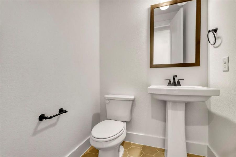 Half bathroom with toilet and light tile patterned floors