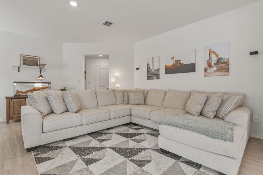 The living room features light-colored flooring and white walls, creating a bright and airy atmosphere