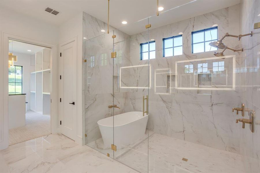 Bathroom featuring marble tiled floors, a marble finish shower, a freestanding bath, recessed lighting, and stone wall