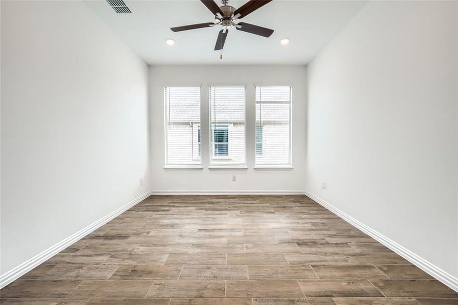 Spare room with wood tiled floors, ceiling fan, and recessed lighting Spare room with wood tiled floors, ceiling fan, and recessed lighting