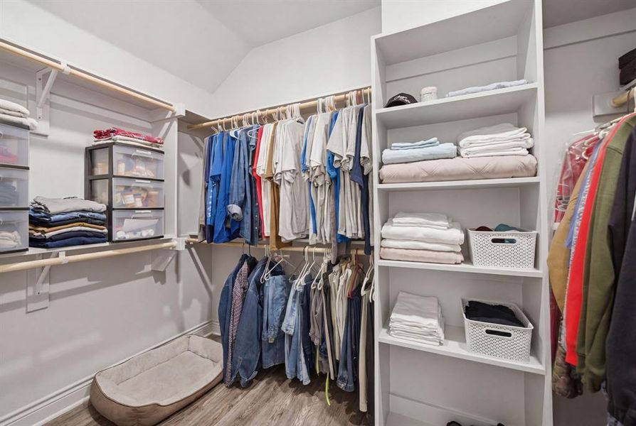 Walk in closet featuring light wood-style flooring and lofted ceiling