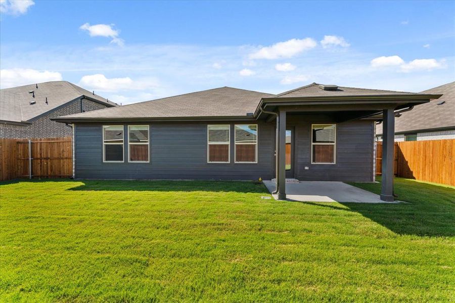 Back of property featuring a yard and a patio