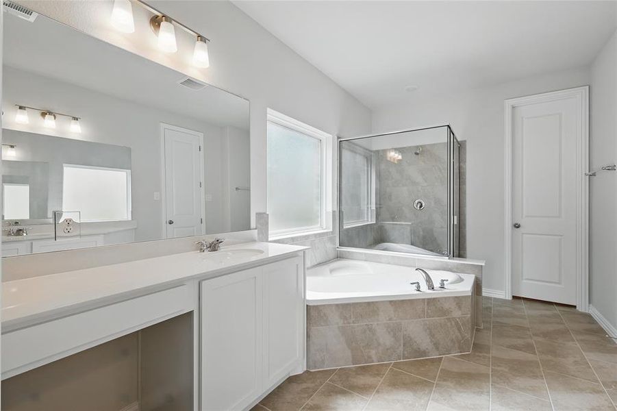 Full bath with a stall shower, vanity, a bath, and light tile patterned floors