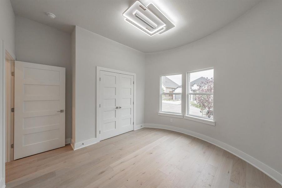 Unfurnished bedroom featuring light wood finished floors and a closet