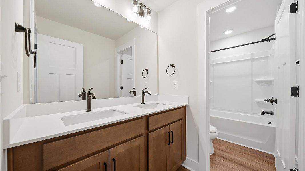First-rate full bath featuring modern surfaces and a fresh, current color palette located at the Iris Meadows community