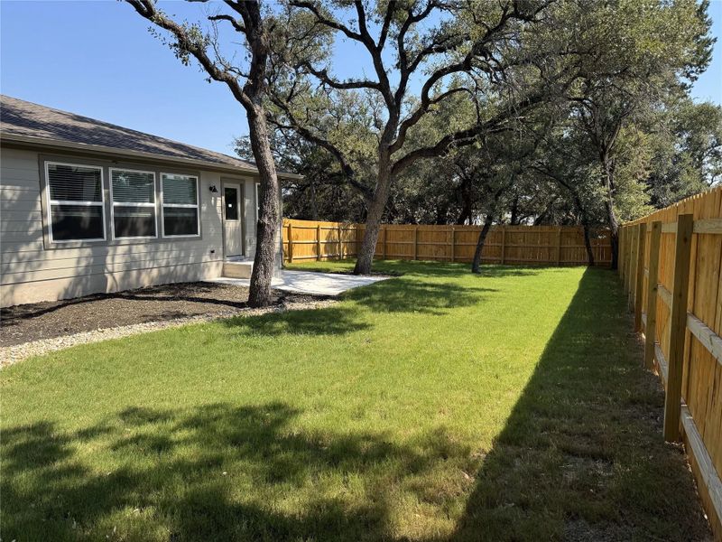 spacious back yard with shade from mature live oak trees