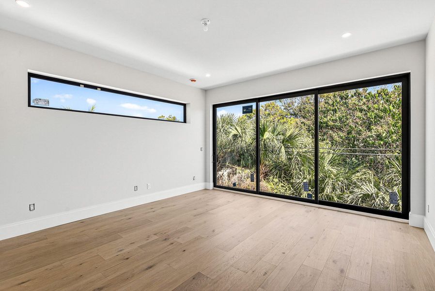 Primary Bedroom with lush views, natural light & wood floors Primary Bedroom with lush views, natural light & wood floors