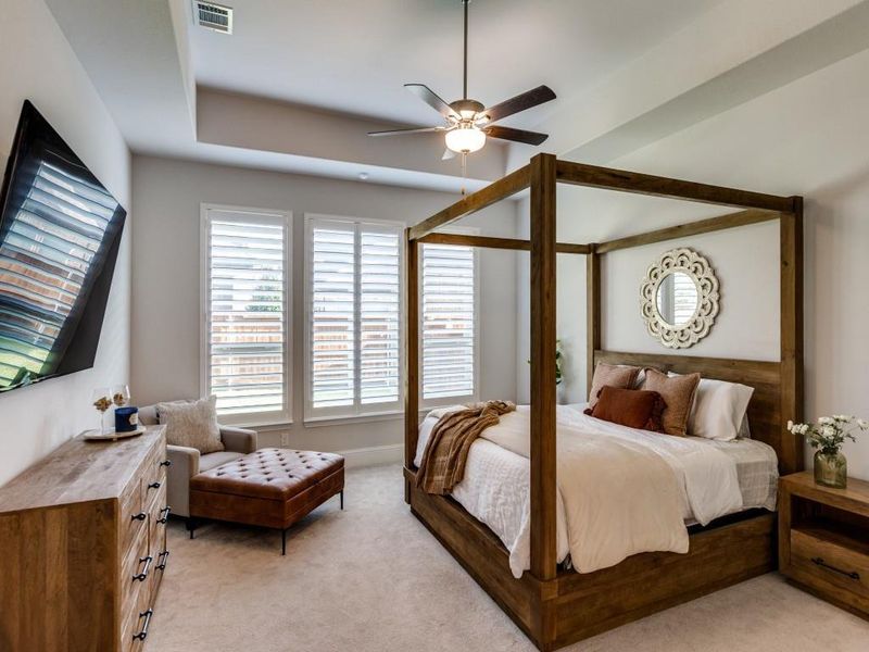Bedroom with light colored carpet and a ceiling fan