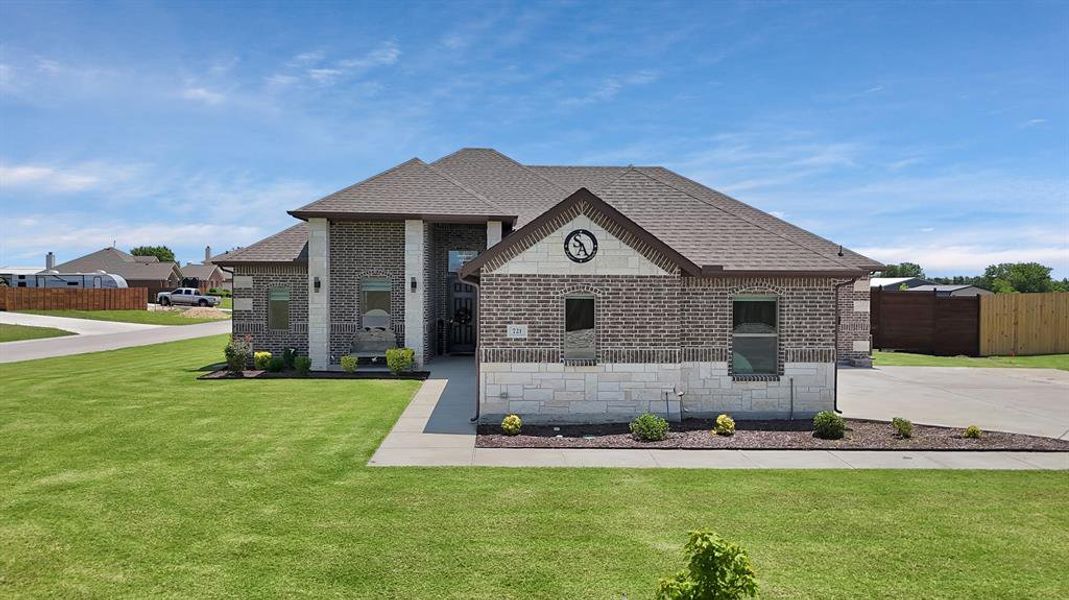 French country inspired facade with brick siding and roof with shingles French country inspired facade with brick siding and roof with shingles
