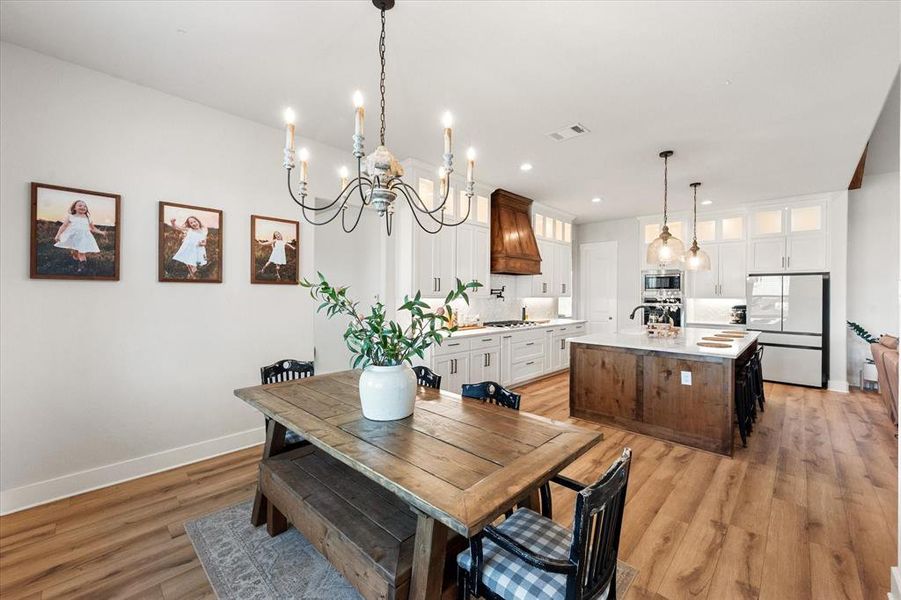 Dining area with light wood finished floors and a chandelier