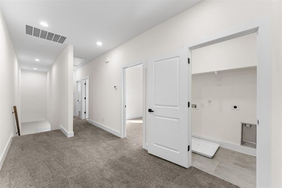 Hall featuring attic access, light colored carpet, recessed lighting, and an upstairs landing Hall featuring attic access, light colored carpet, recessed lighting, and an upstairs landing