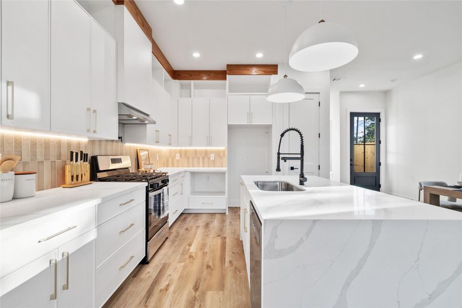 A gourmet chef’s kitchen featuring a sleek, modern design with quartz waterfall countertops on a spacious island, providing both workspace and casual seating. A gourmet chef’s kitchen featuring a sleek, modern design with quartz waterfall countertops on a spacious island, providing both workspace and casual seating.