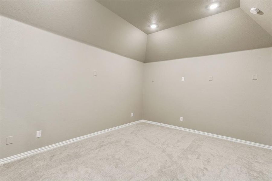 Spare room featuring light colored carpet, recessed lighting, and lofted ceiling