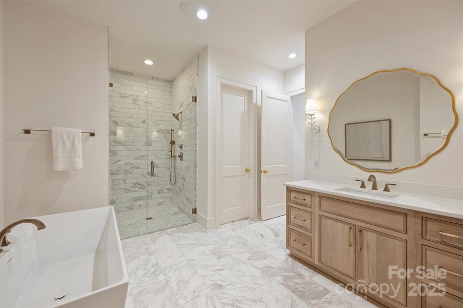 The primary bath features an expansive marble walk-in shower and private water closet.