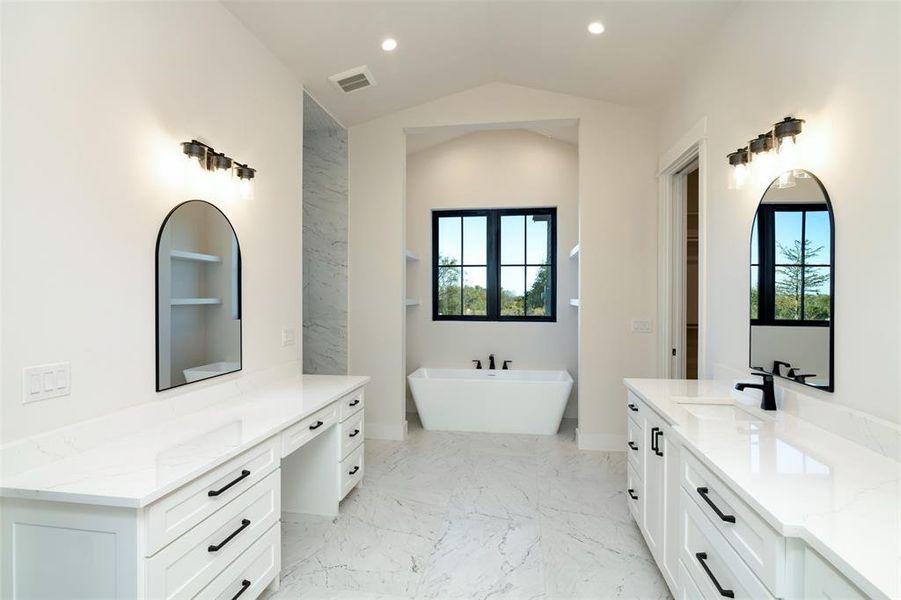 Bathroom featuring vanity, lofted ceiling, and a bathing tub