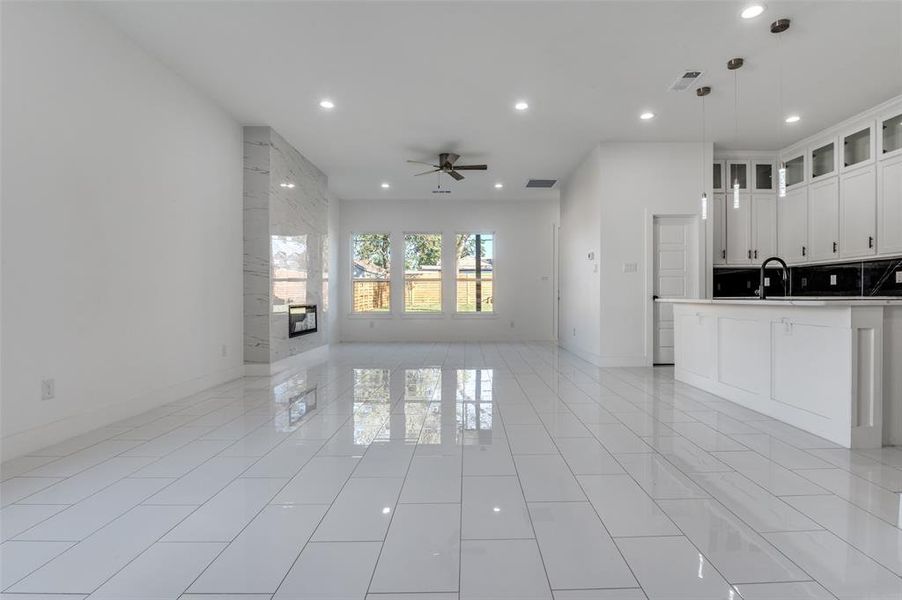 Unfurnished living room featuring recessed lighting, a fireplace, a ceiling fan, and light tile patterned floors