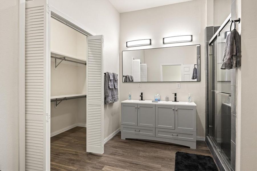 Bathroom featuring an enclosed shower, vanity, and hardwood / wood-style floors