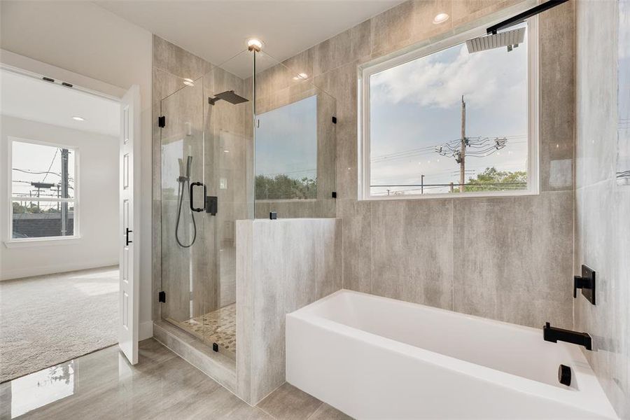Bathroom featuring a garden tub, a shower stall, and light carpet
