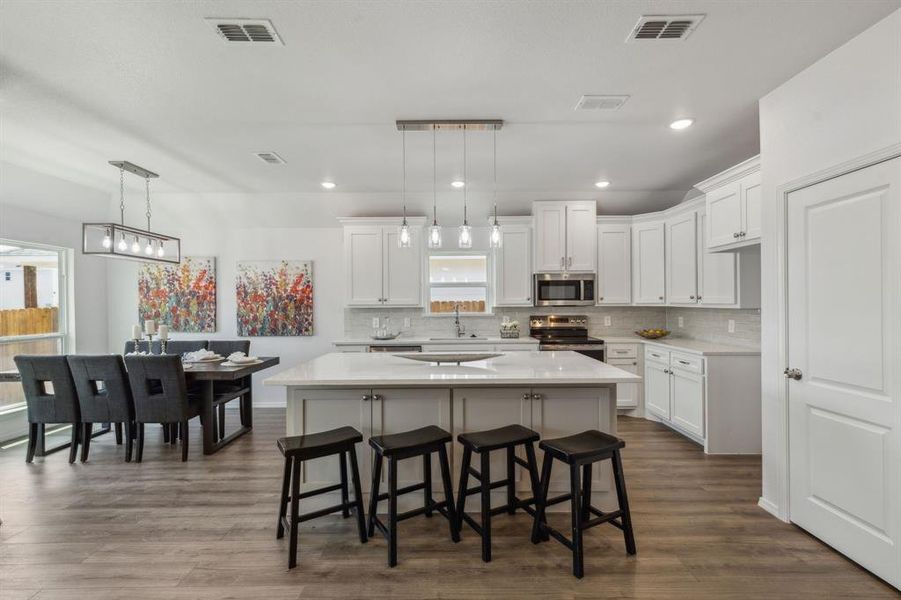 Kitchen featuring appliances with stainless steel finishes, backsplash, plenty of natural light, and dark wood-type flooring