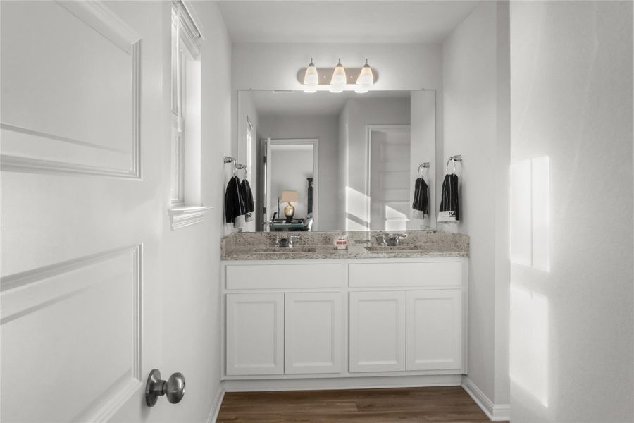 Bathroom featuring double vanity and dark wood-type flooring