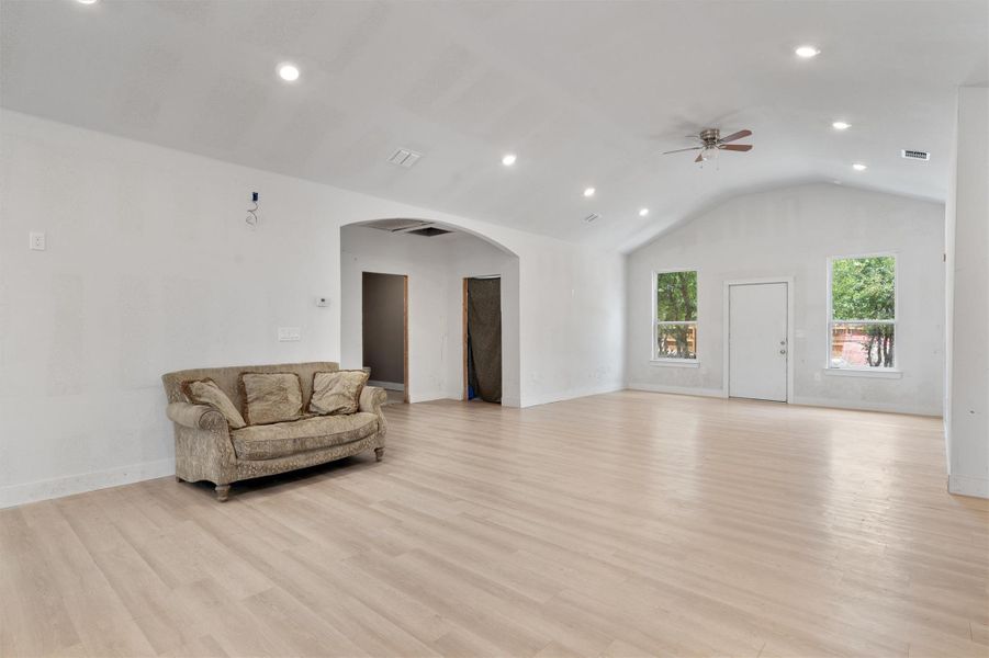 Unfurnished living room with arched walkways, recessed lighting, light wood-style flooring, lofted ceiling, and ceiling fan Unfurnished living room with arched walkways, recessed lighting, light wood-style flooring, lofted ceiling, and ceiling fan