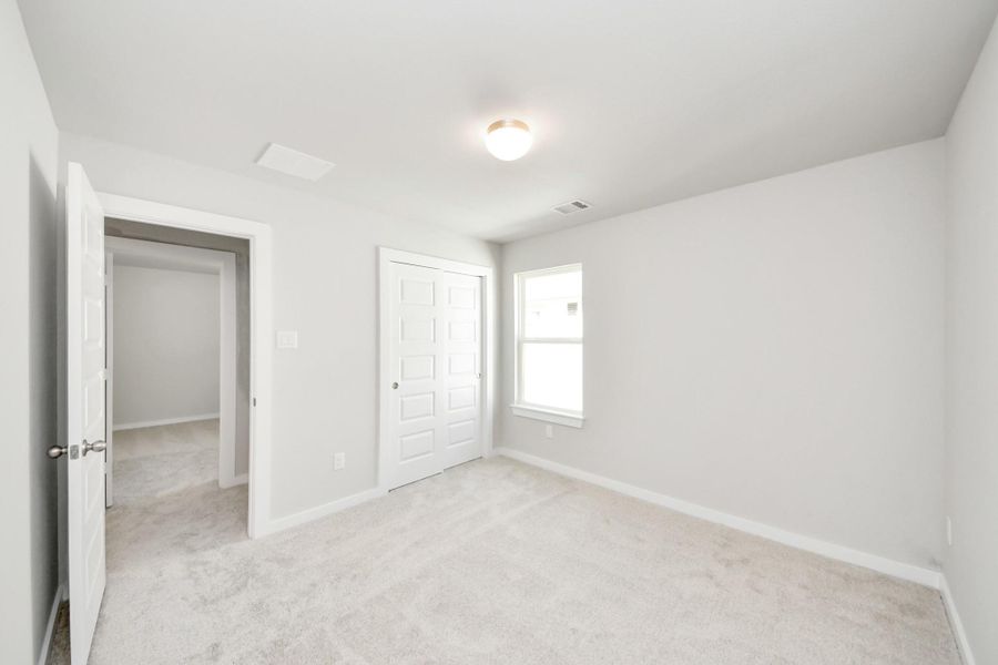 Generously sized secondary bedrooms featuring spacious closets, soft and inviting carpeting underfoot, large windows allowing plenty of natural light, and the added touch of privacy blinds for your personal retreat. Sample photo of completed home with similar floor plan. Actual colors and selections may vary.