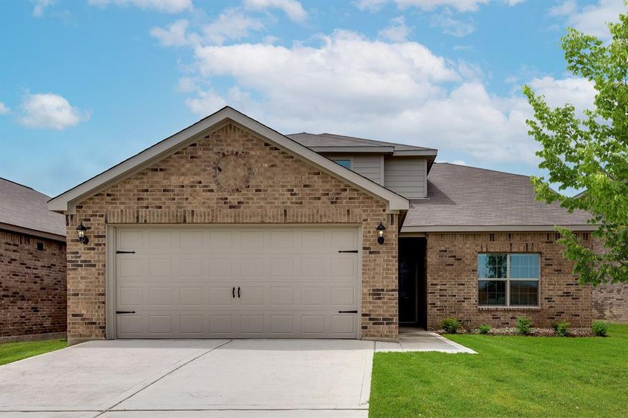 View of front of home with a garage and a front yard