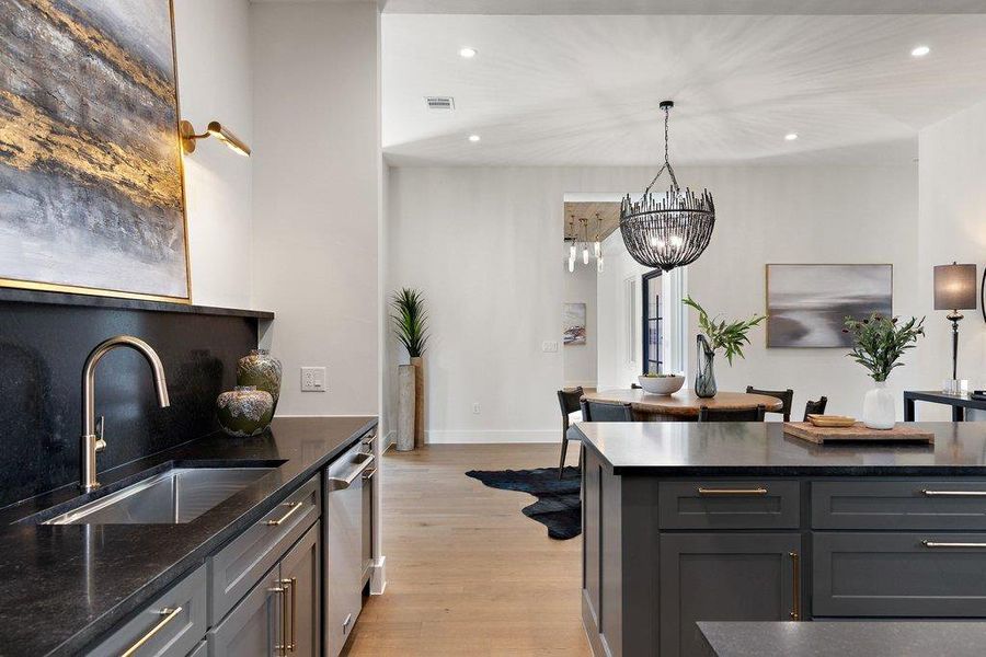 A well-appointed kitchen with dark granite countertops offers both style and functionality, blending seamlessly with the open-concept dining space.