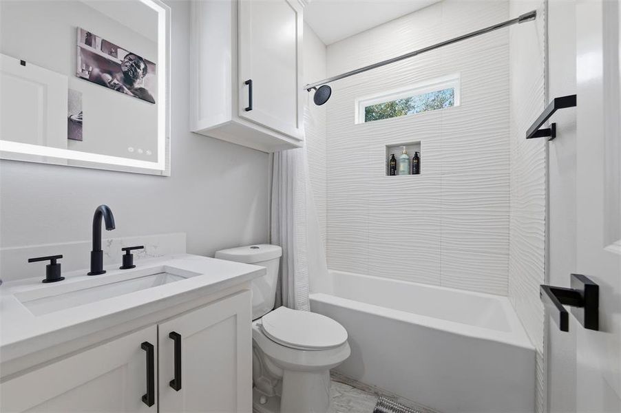 Bathroom featuring vanity and shower / bath combo with shower curtain