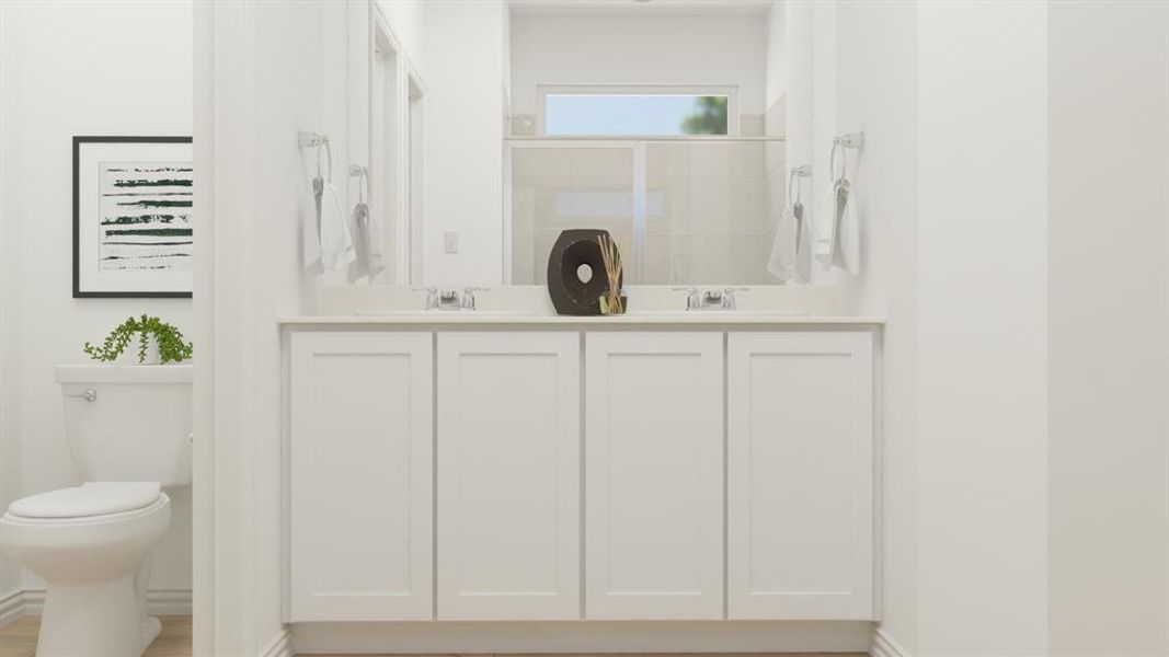 Bathroom with vanity, a shower with door, and toilet