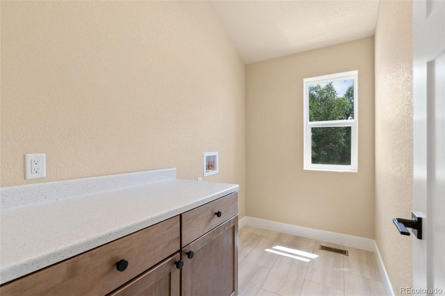 Upper level full laundry room with counter, cabinets/storage, and window Upper level full laundry room with counter, cabinets/storage, and window