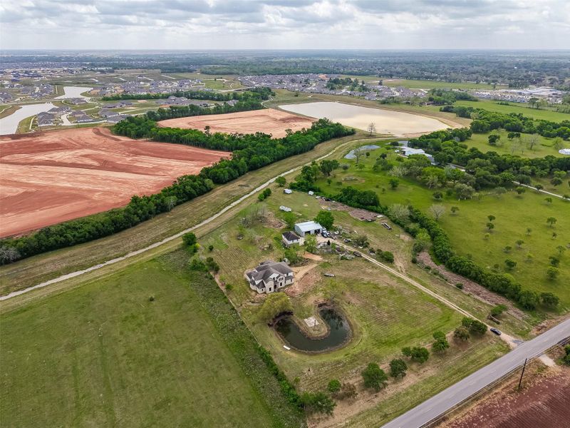 Elevated aerial overview highlighting the full property layout and surrounding farmland.