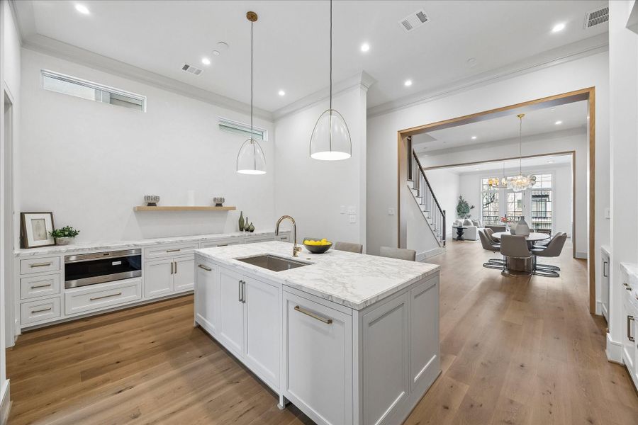 The dining room separates the family room from the kitchen. The open nature of the room means whatever size table you have, it will integrate perfectly. The whimsical Talia chandelier consists of swirled, artisanal glass orbs suspended on a metal frame, creating a dynamic and sculptural light fixture--the perfect focal point for your dining room.