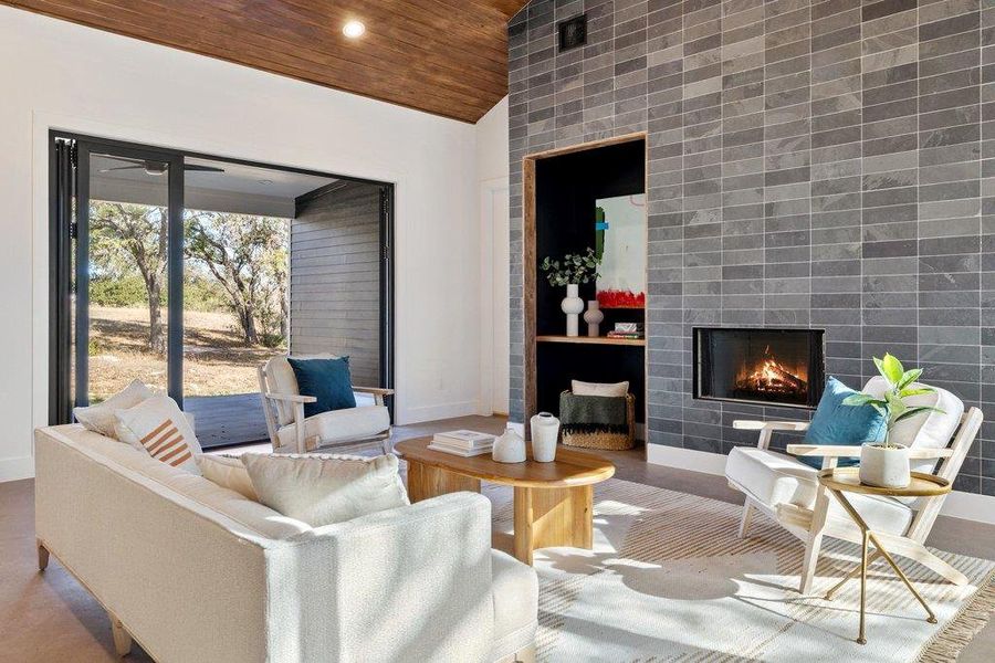 Living area featuring a tiled fireplace, wooden ceiling, high vaulted ceiling, wood finished floors, and recessed lighting