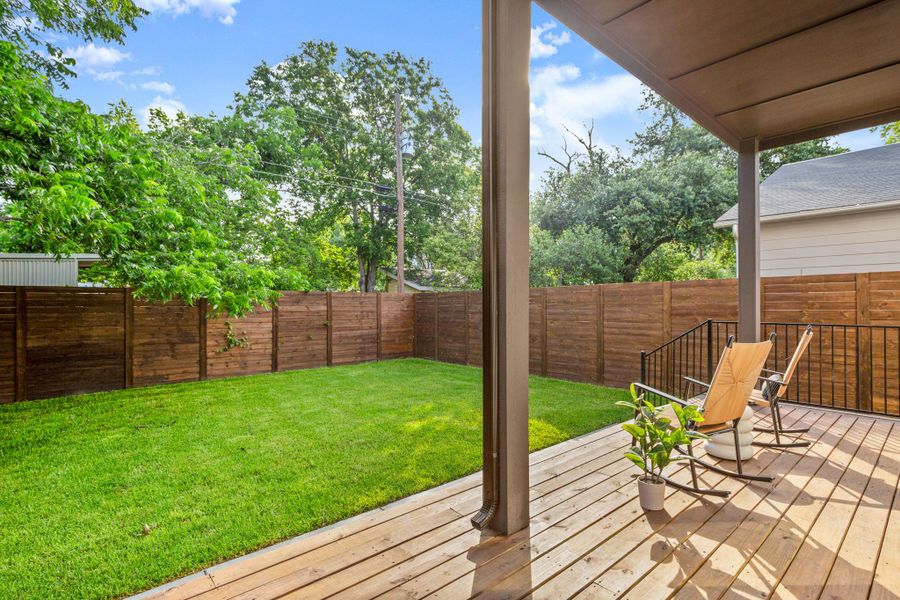 Wooden deck with a fenced backyard and a yard