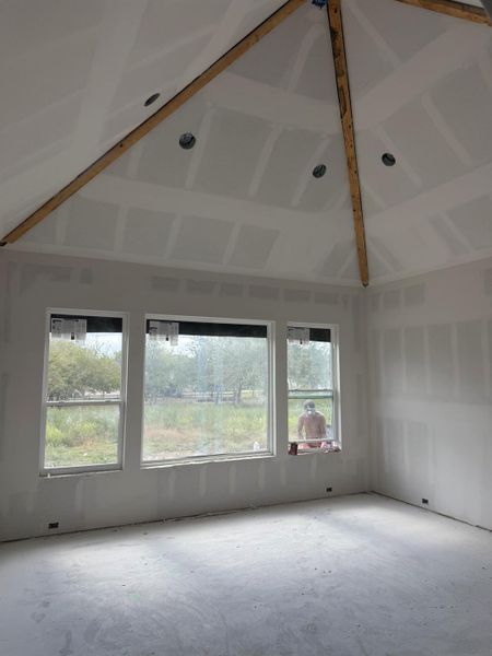 Unfurnished room featuring vaulted ceiling