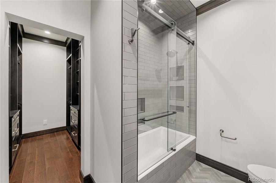 Main floor bedroom ensuite with full bathroom and walk-in custom closet Main floor bedroom ensuite with full bathroom and walk-in custom closet