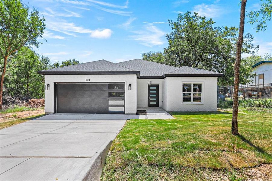 Prairie-style house featuring a front lawn and a garage