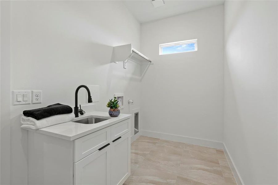 Washroom with cabinet space, light marble finish floors, and gas dryer hookup