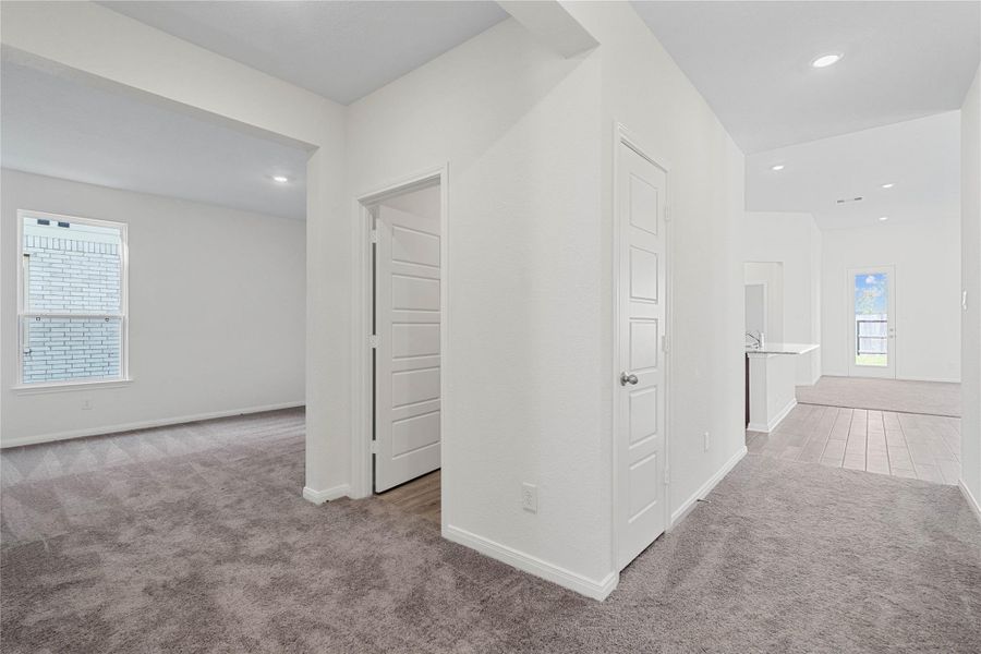 Across the from the secondary bedrooms and bathroom is this spacious hallway to the utility room and the Den!