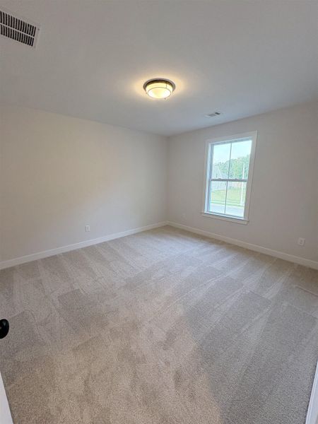 Neutral wall color, wall-to-wall carpeting, overhead lighting fixture, and a window with white trim Neutral wall color, wall-to-wall carpeting, overhead lighting fixture, and a window with white trim