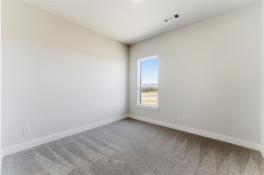 Carpeted spare room with baseboards