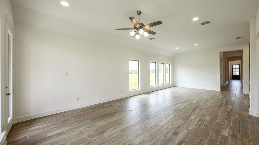 Empty room with recessed lighting, light wood-type flooring, ceiling fan, and lofted ceiling
