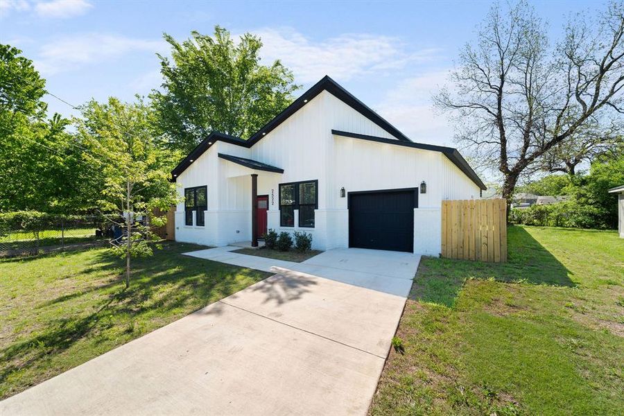 Modern farmhouse style home with a garage and a front lawn