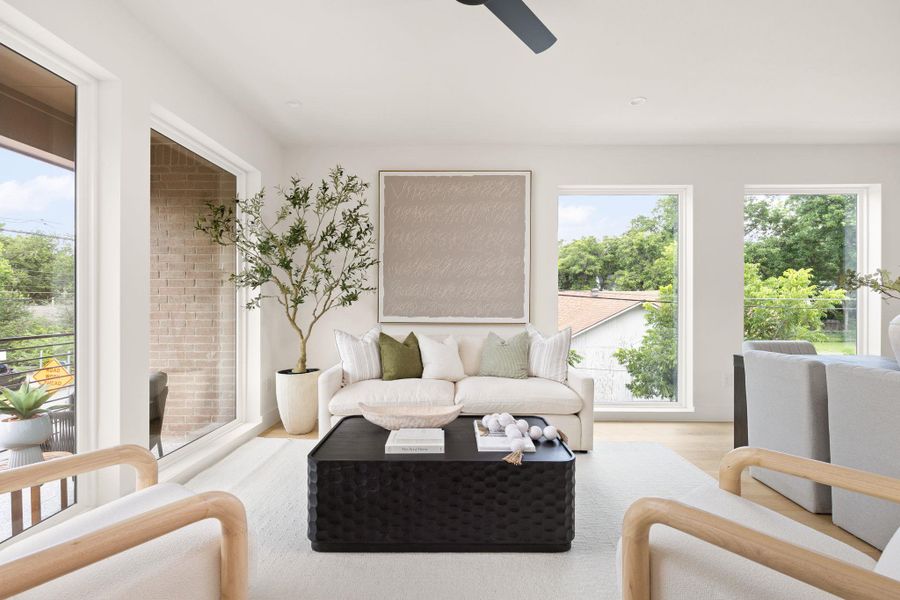 Well-lit living area featuring multiple windows and light hardwood flooring, perfect for gatherings. Well-lit living area featuring multiple windows and light hardwood flooring, perfect for gatherings.