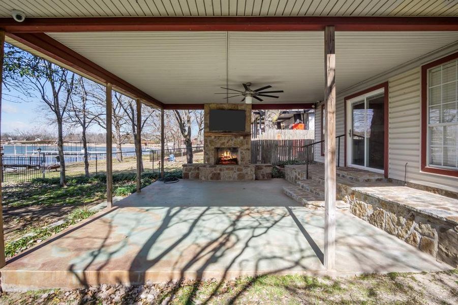 View of patio / terrace with an outdoor stone fireplace and ceiling fan