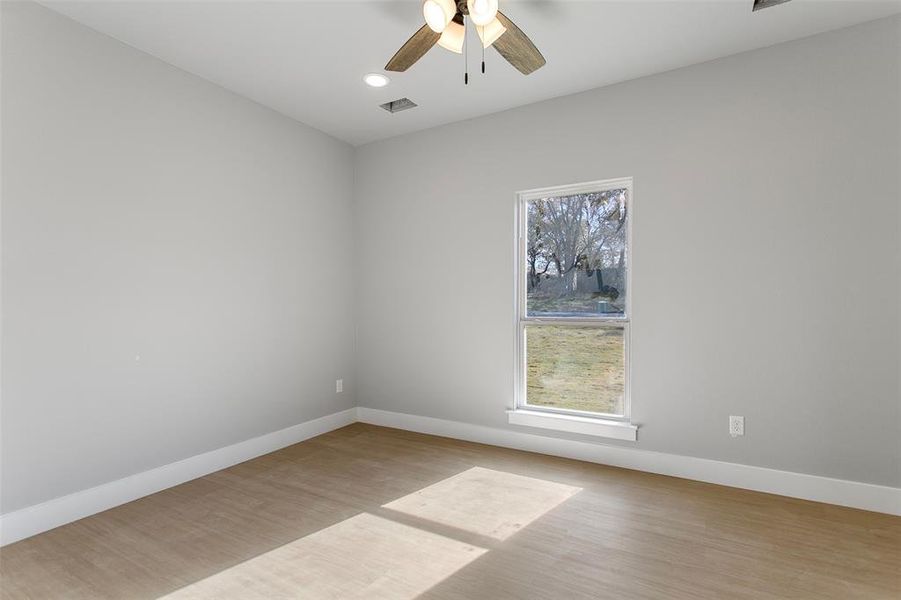 Empty room featuring ceiling fan and light wood-type flooring