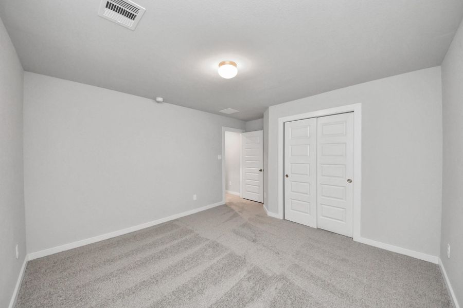 Generously sized secondary bedrooms featuring spacious closets, soft and inviting carpeting underfoot, large windows allowing plenty of natural light, and the added touch of privacy blinds for your personal retreat.