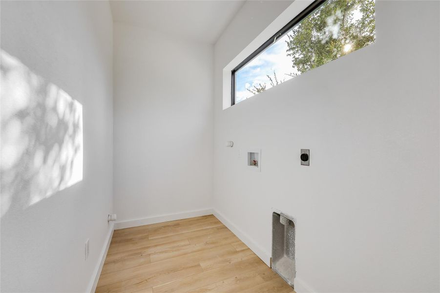 Washroom with washer hookup, light wood finished floors, and hookup for an electric dryer Washroom with washer hookup, light wood finished floors, and hookup for an electric dryer