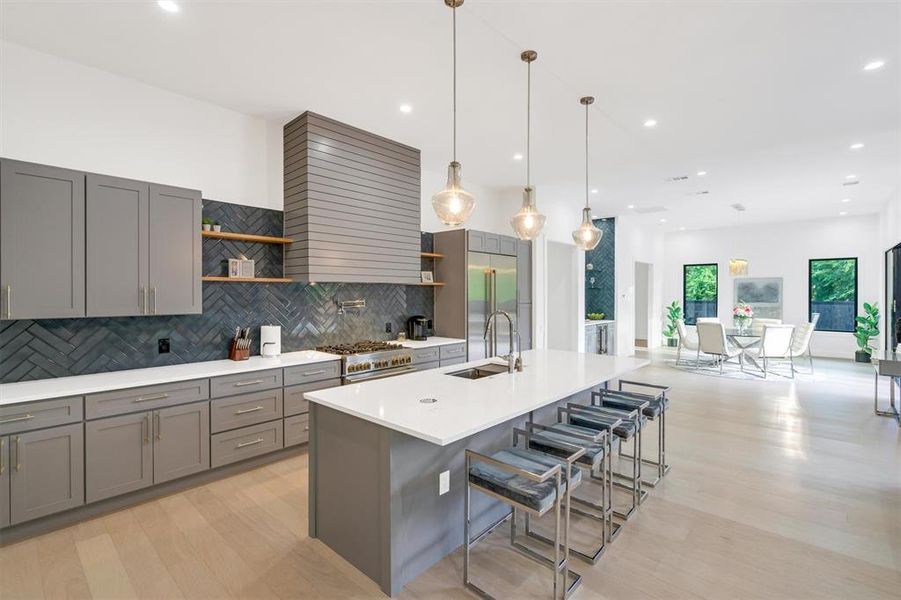 Kitchen featuring a kitchen breakfast bar, open shelves, light wood-style flooring, and a large island